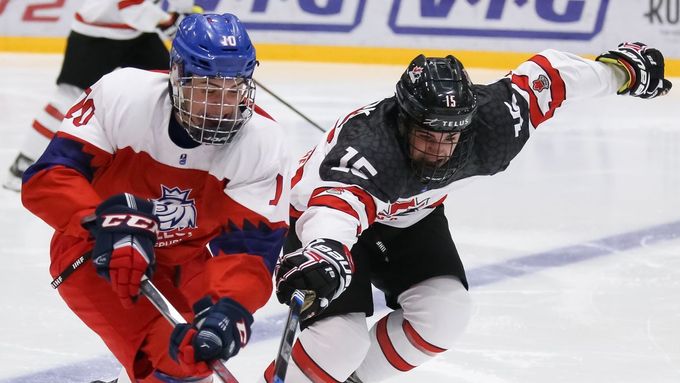 Český hokejista Filip Přikryl bojuje na mistrovství světa hráčů do 18 let o puk s Kanaďanem Alexem Newhookem