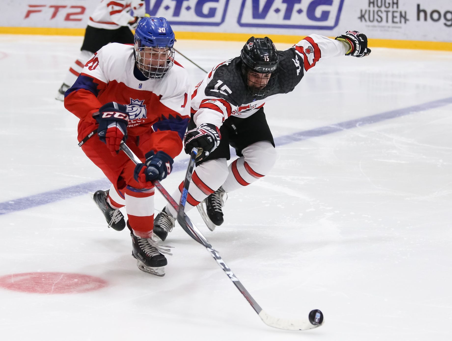 Český hokejista Filip Přikryl bojuje na mistrovství světa hráčů do 18 let o puk s Kanaďanem Alexem Newhookem