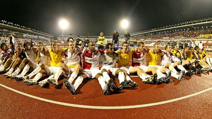 Vítězná Slavia před tribunou svých fanoušků.