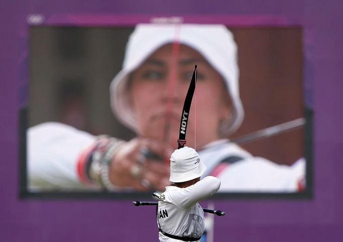 Velkoplošná obrazovka zobrazuje mexickou lukostřelkyni Aidu Romanu (na snímku v popředí) během finálové střelby.