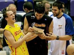 Španělští basketbalisté (zleva) Carlos Jimenez, Jorge Garbajosa a Felipe Reyes se před tréninkem národního týmu smějí nad fotografií v časopise.