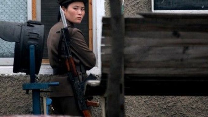 Severokorejská vojákyně hlídkuje ve městě Sinujiu na severokorejské straně řeky Ja-lu, která odděluje Severní Koreu od Číny