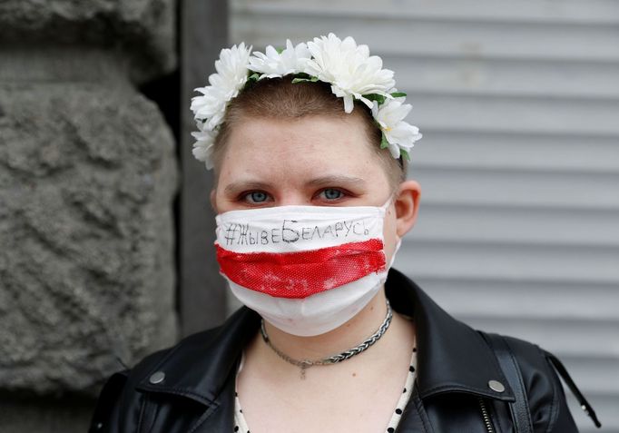 Žena s rouškou v barvách běloruské vlajky při protestech proti policejnímu násilí a průběhu prezidentských voleb.