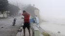 A resident experiences the wind and rain from Tropical Storm Isaac along the coast in the western city of Barahona, August 24, 2012. Tropical Storm Isaac passed the Dominican Republic and headed toward Haiti on Friday, rumbling slowly west across the Caribbean after unleashing heavy rain on parts of Puerto Rico. REUTERS/Ricardo Rojas (DOMINICAN REPUBLIC - Tags: ENVIRONMENT DISASTER) Published: Srp. 24, 2012, 9:48 odp.