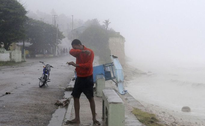 A resident experiences the wind and rain from Tropical Storm Isaac along the coast in the western city of Barahona, August 24, 2012. Tropical Storm Isaac passed the Dominican Republic and headed toward Haiti on Friday, rumbling slowly west across the Caribbean after unleashing heavy rain on parts of Puerto Rico. REUTERS/Ricardo Rojas (DOMINICAN REPUBLIC - Tags: ENVIRONMENT DISASTER) Published: Srp. 24, 2012, 9:48 odp.