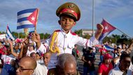 Havana, Kuba: chlapec v uniformě sedí na ramenou svého dědečka během každoročního prvomájového průvodu na Náměstí revoluce.