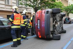 Řidič v Praze naboural čtyři zaparkovaná auta, svoje BMW převrátil na bok. Z místa utekl