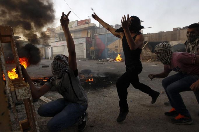 Palestinian youths throw stones towards Israeli border police (not seen) in the Shuafat refugee camp in the West Bank near Jerusalem September 18, 2012. Clashes between police and protesters erupted following a protest against a film mocking the Prophet Mohammad. REUTERS/Ammar Awad (JERUSALEM - Tags: POLITICS CIVIL UNREST TPX IMAGES OF THE DAY) Published: Zář. 18, 2012, 5:52 odp.