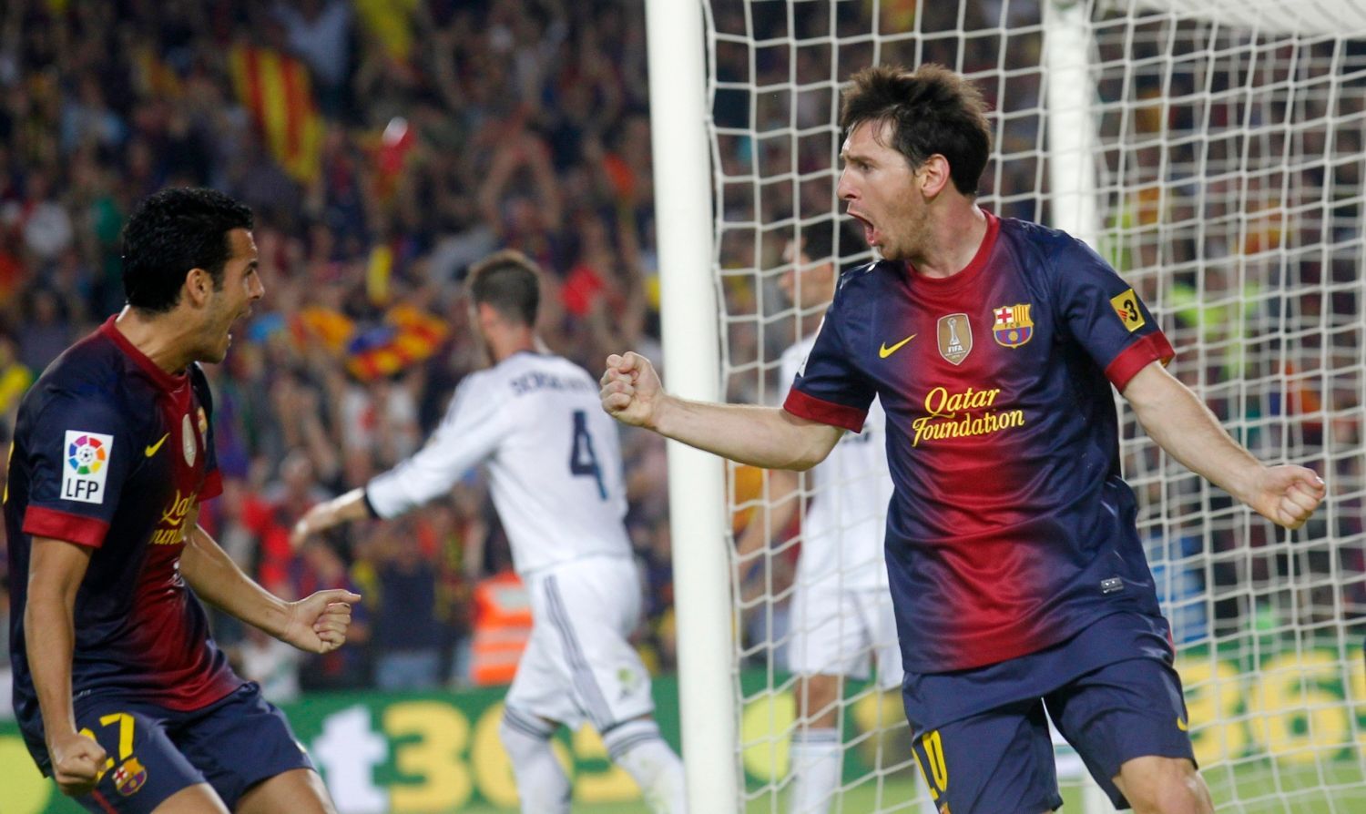 Fotbalisté Barcelony Lional Messi (vpravo) a Pedro Rodriguéz slaví gól v utkání Primera División proti Realu Madrid.