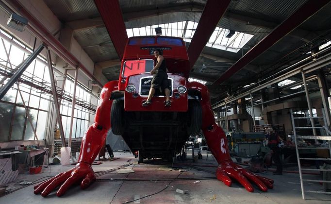 Artist David Cerny enjoys a ride on a London bus that he is transforming into a robotic sculpture July 2, 2012. The bus, which Cerny hopes could become an unofficial mascot of the London 2012 Olympic Games, does push-ups with the help of an engine powering a pair of robotic arms, and the motion is accompanied by a recording of sounds evoking tough physical effort. It will be parked outside the Czech Olympic headquarters in London for the duration of the Games. Picture taken July 2, 2012. REUTERS/Petr Josek (CZECH REPUBLIC - Tags: SOCIETY SPORT OLYMPICS TPX IMAGES OF THE DAY TRANSPORT) Published: Čec. 22, 2012, 5:58 odp.