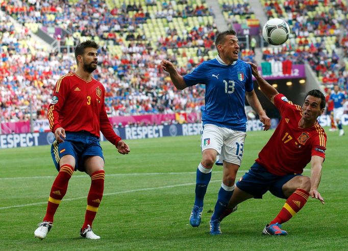 Alvaro Arbeloa a Emanuele Giaccherini v souboji, který sleduje Gerard Piqué během utkání základní skupiny mezi Španělskem a Itálií na Euru 2012.