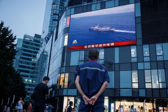 Číňané sledují na velkoplošné obrazovce v Pekingu manévry kolem Tchaj-wanu.