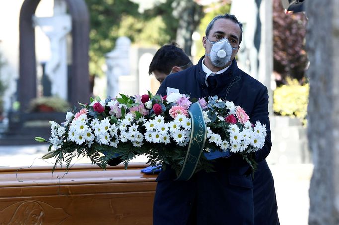 Pohřební ceremonie na severu Itálie za přítomnosti kněze a pohřební služby v rouškách. Některé společnosti nabízejí pozůstalým video přenos.