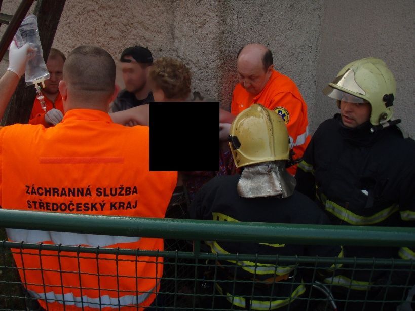 Hasiči vyprošťují ženu, která se po pádu ze schodů nabodla na plot