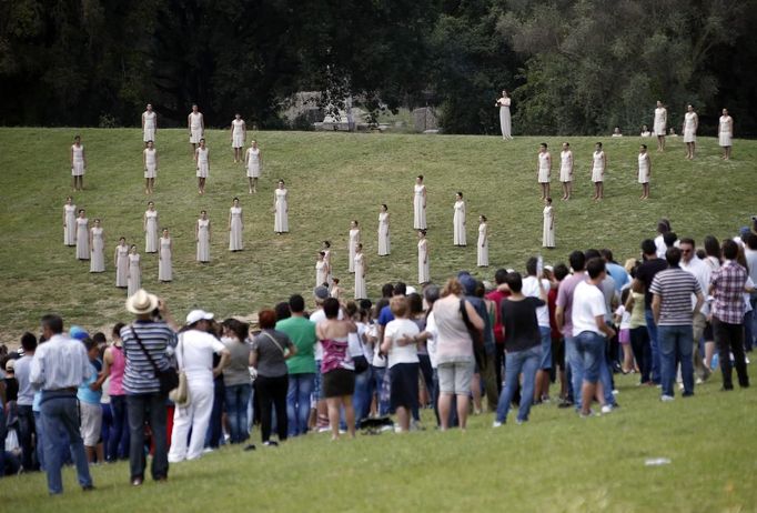 Spectators watch as actors take part in the torch lighting ceremony of the London 2012 Olympic Games at the site of ancient Olympia in Greece May 10, 2012. REUTERS/Kevin Coombs (GREECE - Tags: SPORT OLYMPICS) Published: Kvě. 10, 2012, 11:12 dop.