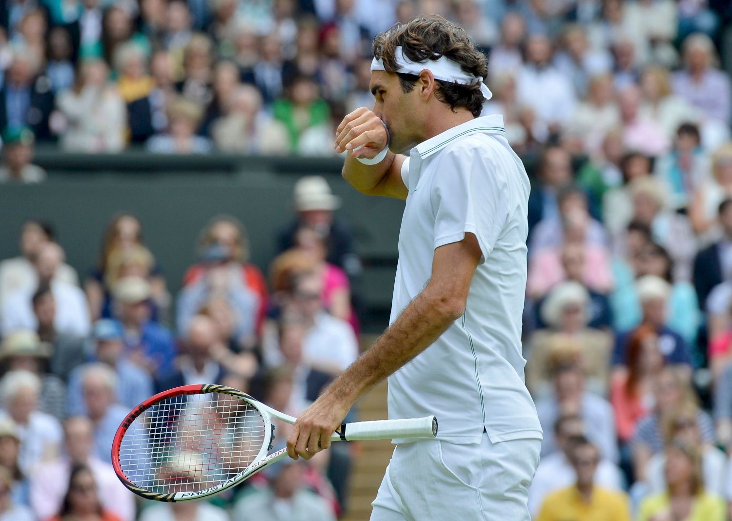 Švýcarský tenista Roger Federer se utírá během utkání s Britem Andym Murraym ve finále Wimbledonu 2012.