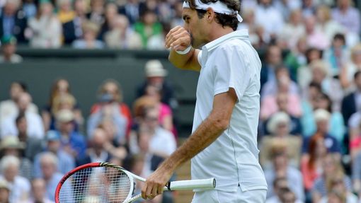 Švýcarský tenista Roger Federer se utírá během utkání s Britem Andym Murraym ve finále Wimbledonu 2012.
