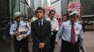 A representative (C) from the Japanese consulate is escorted by security guards carrying protest letters, as protesters follow behind, carrying Japanese Self-Defense Force flags demonstrate against Japan's decision to nationalise the islands, called Senkaku by Japan and Diaoyu by China, outside the Japanese Consulate in Hong Kong September 18, 2012. Japanese businesses shut hundreds of stores and plants and the country's embassy suspended services in China on Tuesday as anti-Japan protests reignited and risked dragging a territorial dispute between Asia's two biggest economies deeper into crisis. Chinese characters on the flags read, "Down with Japanese militarism". REUTERS/Bobby Yip (CHINA - Tags: POLITICS CIVIL UNREST TPX IMAGES OF THE DAY)