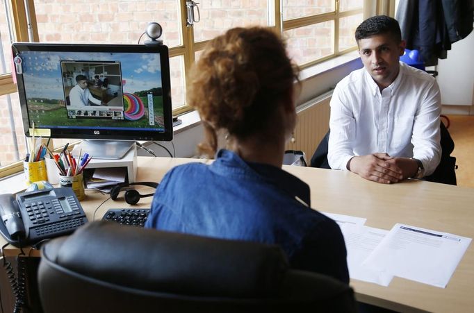 Unemployed Belgian Mohamed Sammar (R) answers questions during a simulated job interview, which is recorded to help him get feedback afterwards in Brussels July 2, 2013. Sammar, 27, has been looking for a job in the construction sector for 2 years. "Fit for a job" is the initiative of former Belgian boxing champion Bea Diallo, whose goal was to restore the confidence of unemployed people and help them find a job through their participation in sports. Picture taken July 2, 2013. REUTERS/Francois Lenoir (BELGIUM - Tags: SPORT BOXING SOCIETY BUSINESS EMPLOYMENT) Published: Čec. 5, 2013, 4:48 odp.