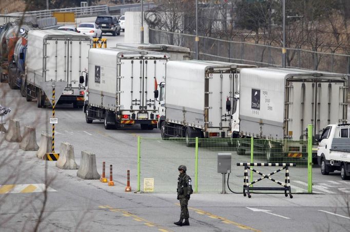 A South Korean soldier keeps watch as South Korean trucks leave the South's CIQ (Customs, Immigration and Quarantine) office to go to the inter-Korean Kaesong Industrial Complex in North Korea, just south of the demilitarised zone separating the two Koreas, in Paju, north of Seoul, April 1, 2013. North Korea said on Saturday it was entering a "state of war" with South Korea, but Seoul and the United States played down the statement as tough talk. Pyongyang also threatened to close a border industrial zone, the last remaining example of inter-Korean cooperation which gives the North access to $2 billion in trade a year. REUTERS/Lee Jae-Won (SOUTH KOREA - Tags: MILITARY POLITICS BUSINESS) Published: Dub. 1, 2013, 2:38 dop.