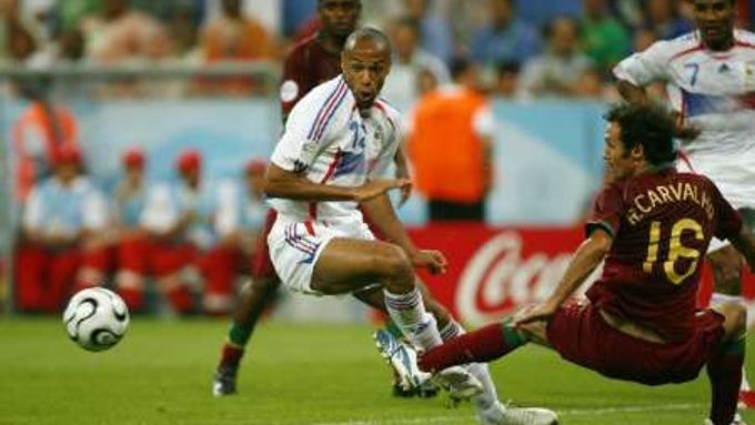 Portugalec Ricardo Carvalho (v červeném) fauluje v pokutovém území Thierry Henryho z Francie.
