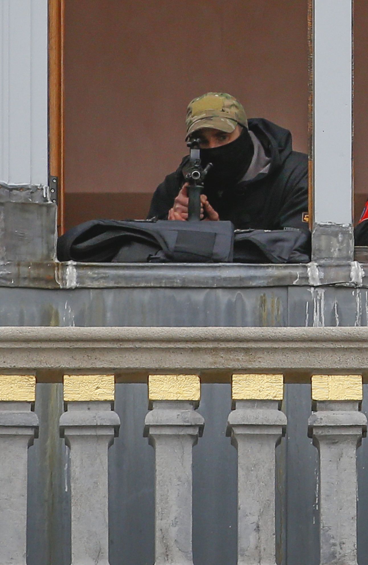 Odstřelovač belgických speciálních sil hlídá z balkónu hlavní bruselské náměstí.