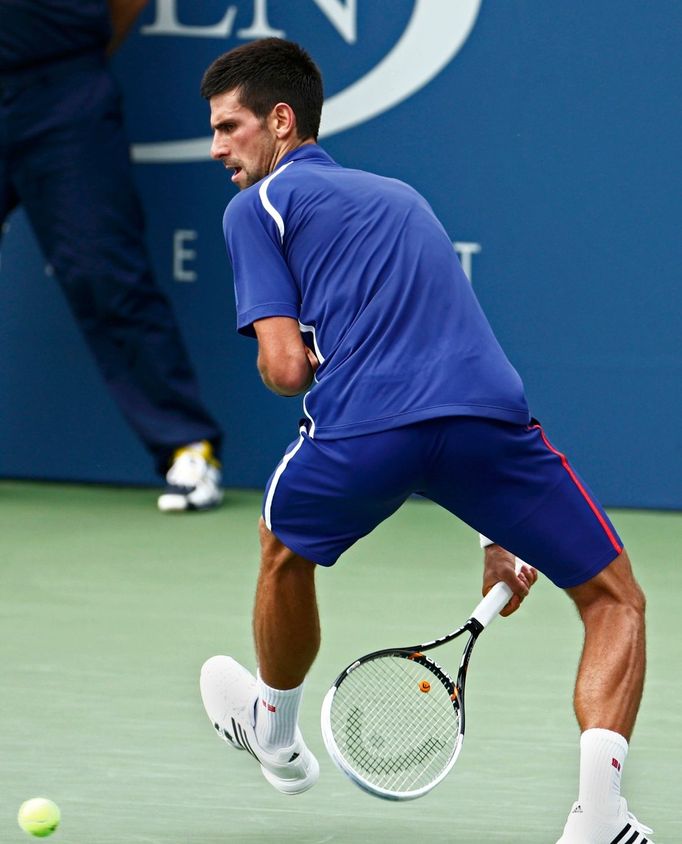 Srbský tenista Novak Djokovič odráží míček na Švýcara Stanislase Wawrinku na US Open 2012.