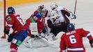 Hokejový brankář Tomáš Pöpperle zabraňuje gólu před Andrisem Džerinšem v utkání KHL 2012/13 mezi Lvem Praha s Dinamem Riga .