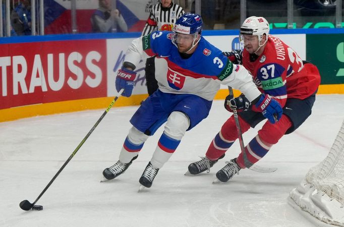 Slovák Adam Jánošík si kryje puk před Norem Markusem Vikingstadem