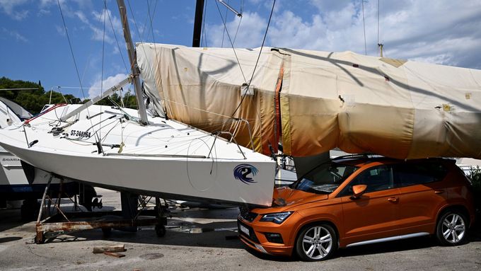 A car and boats are damaged in Split, Croatia, Tuesday, July 8, 2025, following a powerful storm. (AP Photo/Tom Dubravec)