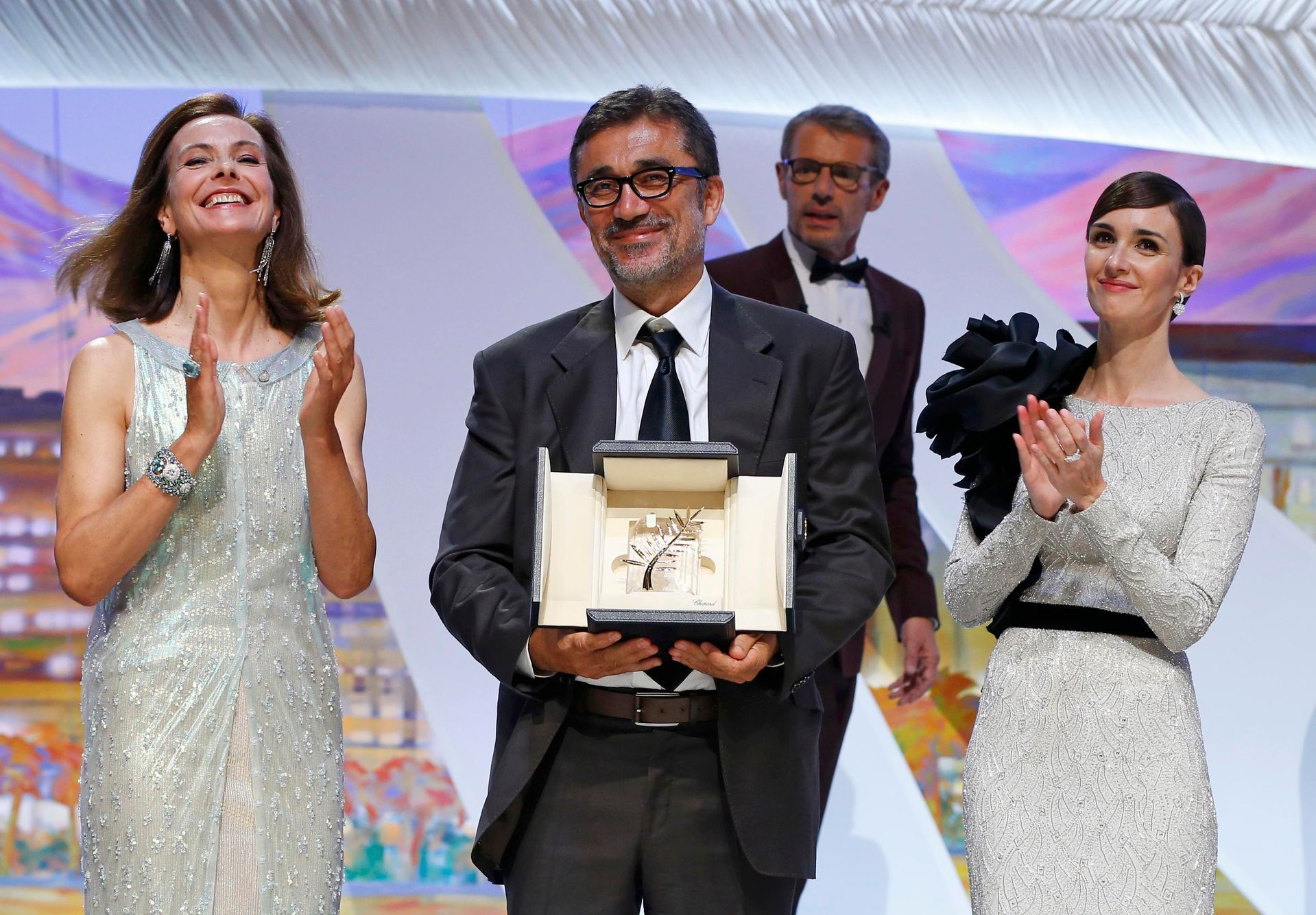 Director Nuri Bilge Ceylan, Palme d'Or award winner for his film &quot;Winter Sleep&quot;, poses on stage with jury member Carole Bouquet and actress Paz Vega during the closing ceremony of the 67th C