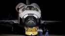 Ground crew take photos before the space shuttle Discovery is lifted at the Mate Demate Facility at Kennedy Space Center