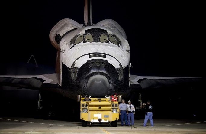 Ground crew take photos before the space shuttle Discovery is lifted at the Mate Demate Facility at Kennedy Space Center