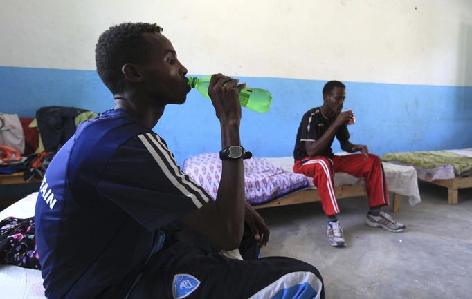 Somali athletes drink water and rest inside their room after training during preparations for the 2012 London Olympic Games in Somalia's capital Mogadishu in this March 14, 2012 file photo. Training in a bullet-riddled stadium where the remains of a rocket propelled grenade lies discarded on the track's edge counts as progress for Somali Olympic hopeful Mohamed Hassan Mohamed. A year ago, Mogadishu's Konis stadium was a base for Islamist militants and a work out meant at times running through the streets, dodging gun-fire and mortar shells in one of the world's most dangerous cities. To match OLY-SOMALIA-HOPES/ REUTERS/Feisal Omar/Files (SOMALIA - Tags: SPORT ATHLETICS SOCIETY OLYMPICS) Published: Čer. 11, 2012, 6:55 dop.