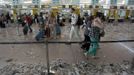 Passengers walk near check-in desks during a protest by the cleaning staff at Barcelona's airport May 29, 2012. Cleaning staff working for a company which has a contract with the airport demonstrated against pay and benefits cuts made by their employer. REUTERS/Albert Gea (SPAIN - Tags: CIVIL UNREST BUSINESS TRANSPORT) Published: Kvě. 29, 2012, 5:09 odp.