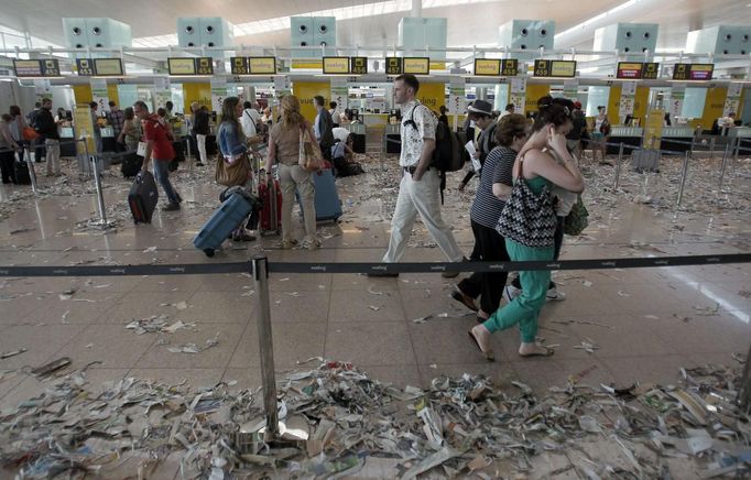 Passengers walk near check-in desks during a protest by the cleaning staff at Barcelona's airport May 29, 2012. Cleaning staff working for a company which has a contract with the airport demonstrated against pay and benefits cuts made by their employer. REUTERS/Albert Gea (SPAIN - Tags: CIVIL UNREST BUSINESS TRANSPORT) Published: Kvě. 29, 2012, 5:09 odp.