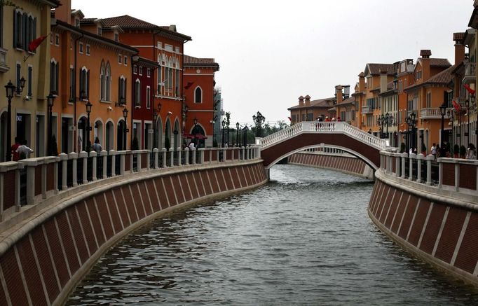 A bridge crosses a canal that flows through the center of the Florentia Village in the district of Wuqing, located on the outskirts of the city of Tianjin June 13, 2012. The shopping center, which covers an area of some 200,000 square meters, was constructed on a former corn field at an estimated cost of US$220 million and copies old Italian-style architecture with Florentine arcades, a grand canal, bridges, and a building that resembles a Roman Coliseum. REUTERS/David Gray (CHINA - Tags: SOCIETY BUSINESS) Published: Čer. 13, 2012, 5:41 odp.