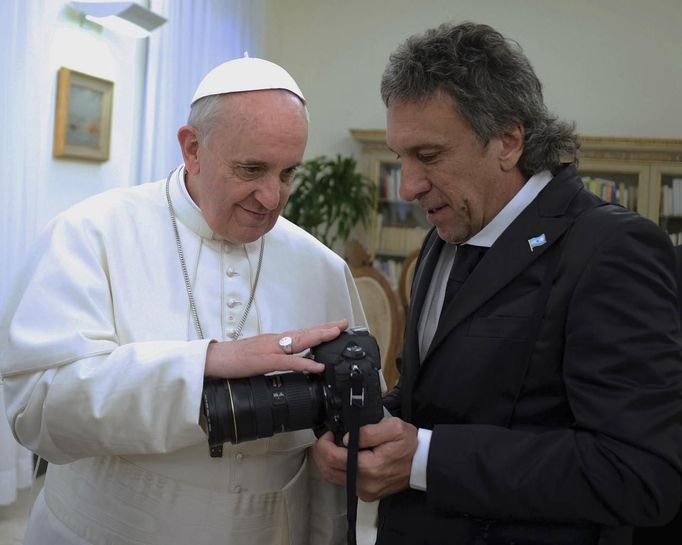 Papež František žehná fotoaparátu Victora Buggeho, oficiálního fotografa argentinské prezidentky Cristiny Fernandez Kirchnerové (není na snímku). Vatikán 18. března 2013.