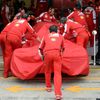 Engineers push the car of Ferrari Formula One driver Felipe