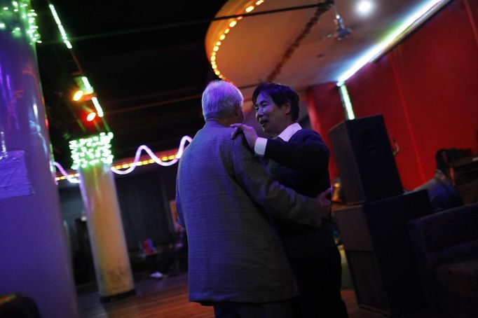 Xiao Cao (R), a 57-year-old gay man, dances with a partner at a gay dance club in Shanghai April 6, 2012. China's gay community has long been on the edges of society but it is gradually becoming more accepted. Cao, who is an unemployed drag queen, is one whose life lifts the curtain on a less romanticised view of Chinese homosexuals. Living in an eight-square-metre apartment behind a public toilet and with a monthly income of 500 yuan ($79) from social insurance, he passes his days dancing in public and spending time with friends at gay clubs. Picture taken April 6, 2012. REUTERS/Aly Song (CHINA - Tags: SOCIETY) CHINA OUT. NO COMMERCIAL OR EDITORIAL SALES IN CHINA. ATTENTION EDITORS PICTURE 22 OF 28 OF PACKAGE 'GAY AND OUT IN CHINA' TO FIND ALL IMAGES SEARCH 'GAY OUT CHINA' Published: Čer. 1, 2012, 12:40 dop.