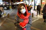 Íránská dívka pózuje se srdíčkem na ulici v íránském Teheránu.