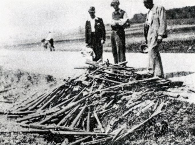 Hromada zbraní odzbrojených jednotek SS u strakonické silnice procházející Milínem nedaleko Slivice po skončení bojů. 12. květen 1945.