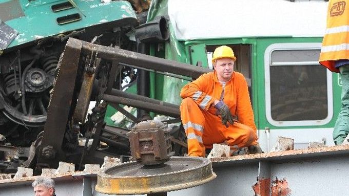Dělníci odpočívají při odklízení trosek z železniční trati ve Studénce. Původní odhady po pátečním neštěstí počítaly s tím, že trať tu bude neprůjezdná asi pět dnů