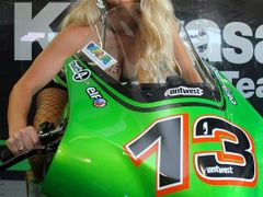 Vnadná kráska pózuje na motocyklu Kawasaki MotoGP v boxech v Sachsenringu.