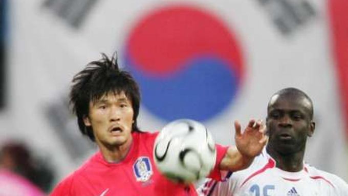 Korejec Cho Jae-jin (vlevo) v souboji o míč s Lilianem Thuramem z Francie.