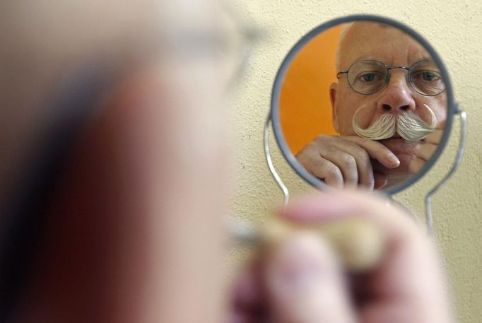 A participant is reflected on a mirror as he gets ready for the 2012 European Beard and Moustache Championships in Wittersdorf near Mulhouse, Eastern France, September 22, 2012. More than a hundred participants competed in the first European Beard and Moustache Championships organized in France. REUTERS/Vincent Kessler (FRANCE - Tags: SOCIETY) Published: Zář. 22, 2012, 7:20 odp.