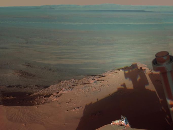 Late Afternoon Shadows at Endeavour Crater on Mars NASA's Mars Rover Opportunity catches its own late-afternoon shadow in this dramatically lit view eastward across Endeavour Crater on Mars. The rover used the panoramic camera (Pancam) between about 4:30 and 5:00 p.m. local Mars time to record images taken through different filters and combined into this mosaic view. Most of the component images were recorded during the 2,888th Martian day, or sol, of Opportunity's work on Mars (March 9, 2012). At that time, Opportunity was spending low-solar-energy weeks of the Martian winter at the Greeley Haven outcrop on the Cape York segment of Endeavour's western rim. In order to give the mosaic a rectangular aspect, some small parts of the edges of the mosaic and sky were filled in with parts of an image acquired earlier as part of a 360-degree panorama from the same location. Opportunity has been studying the western rim of Endeavour Crater since arriving there in August 2011. This crater spans 14 miles (22 kilometers) in diameter, or about the same area as the city of Seattle. This is more than 20 times wider than Victoria Crater, the largest impact crater that Opportunity had previously examined. The interior basin of Endeavour is in the upper half of this view. The mosaic combines about a dozen images taken through Pancam filters centered on wavelengths of 753 nanometers (near infrared), 535 nanometers (green) and 432 nanometers (violet). The view is presented in false color to make some differences between materials easier to see, such as the dark sandy ripples and dunes on the crater's distant floor. Image credit: NASA/JPL-Caltech/Cornell/Arizona State Univ.