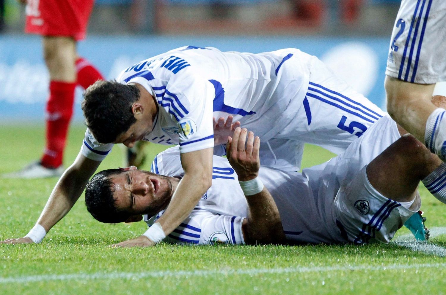 Izraelští fotbalisté Tomer Hemed (dole) a Maor Melikson oslavují gól v kvalifikaci na MS 2014 proti Lucembursku.