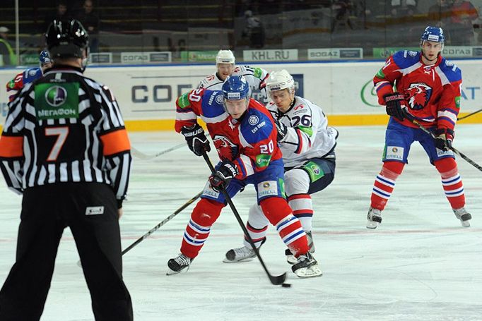 Hokejisté Lva Praha Petr Vrána před Jonasem Enlundem v utkání KHL 2012/13 proti Novosibirsku.