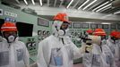 An employee (C) of Tokyo Electric Power Co. (TEPCO) measures using a dosimeter at the central operating control room of the No. 1 and No. 2 reactors at TEPCO's tsunami-cr